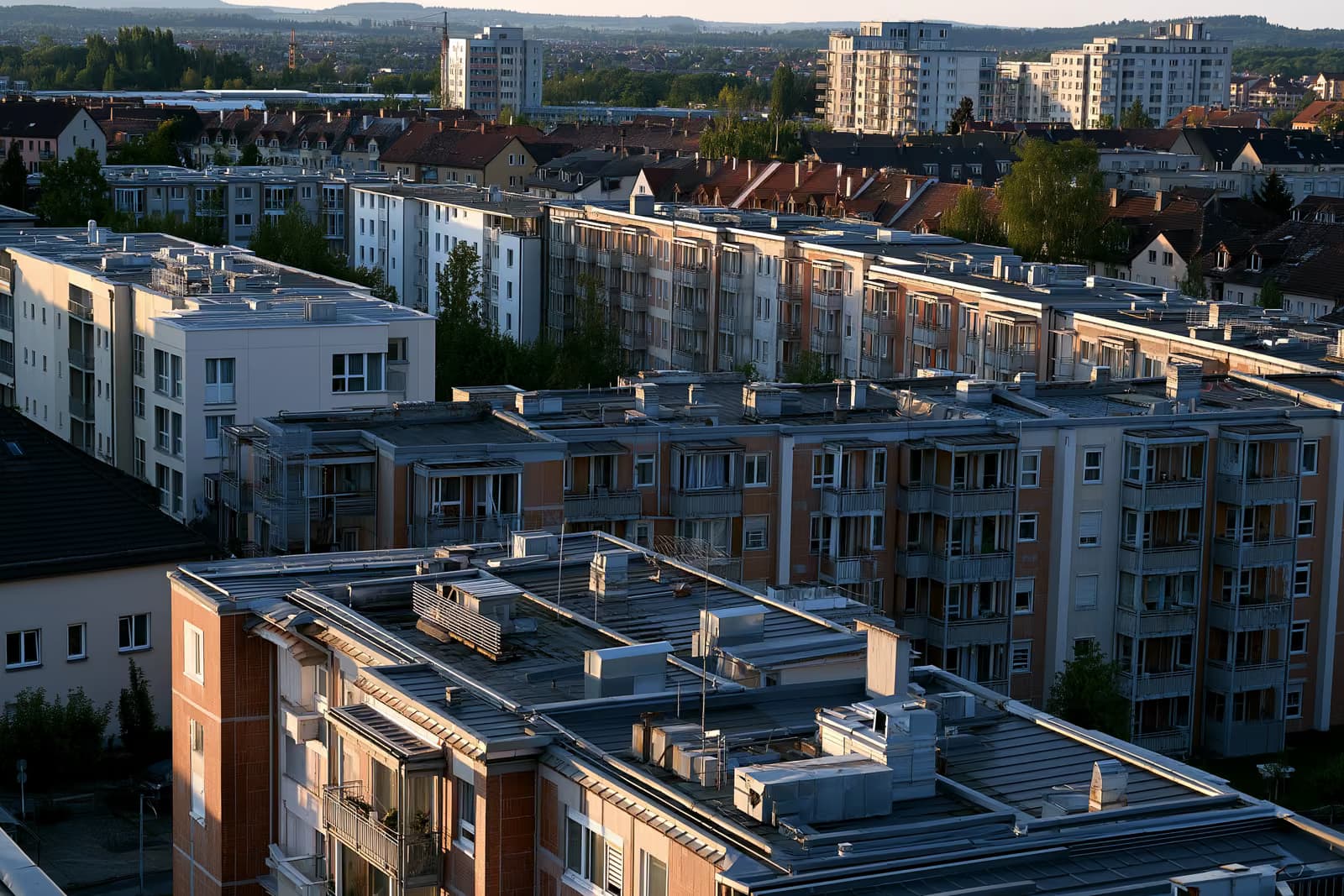 Дахи та вентиляційні отвори опалення на житлових будинках у німецькому місті під теплим післяобіднім світлом.