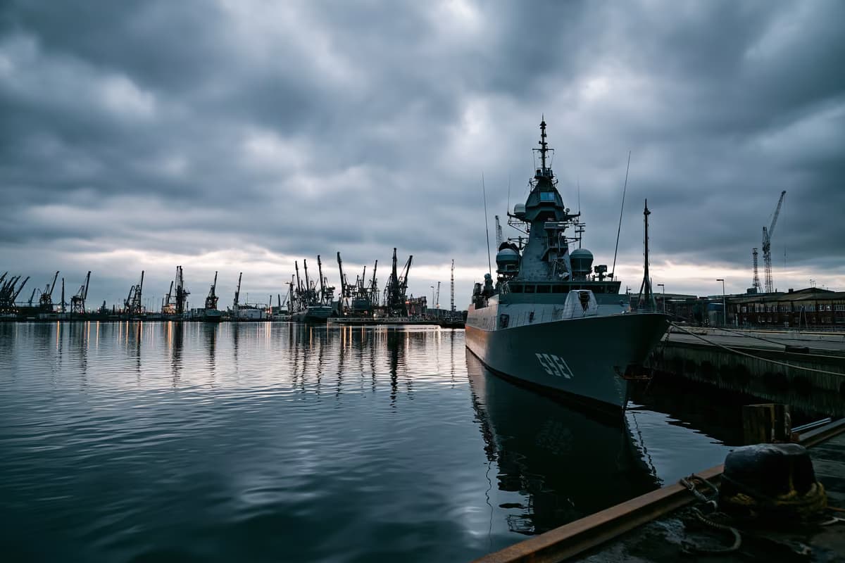 Сіра військово-морська верф під похмурим небом, що свідчить про інвестиції в оборону.